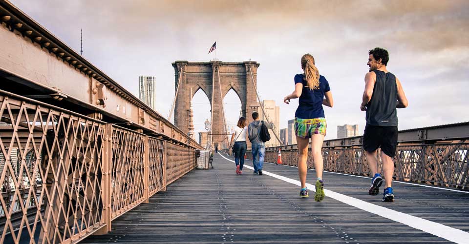 people jogging on a bridge